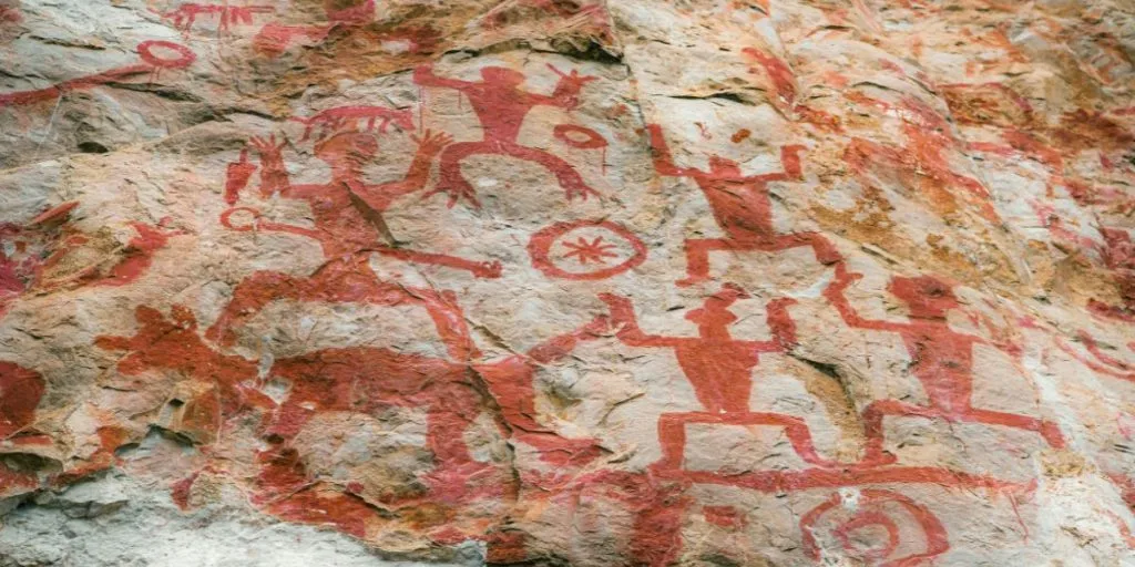 Red-painted figures on a limestone cliff at the Zuojiang Huashan rock art site in Guangxi, southern China.