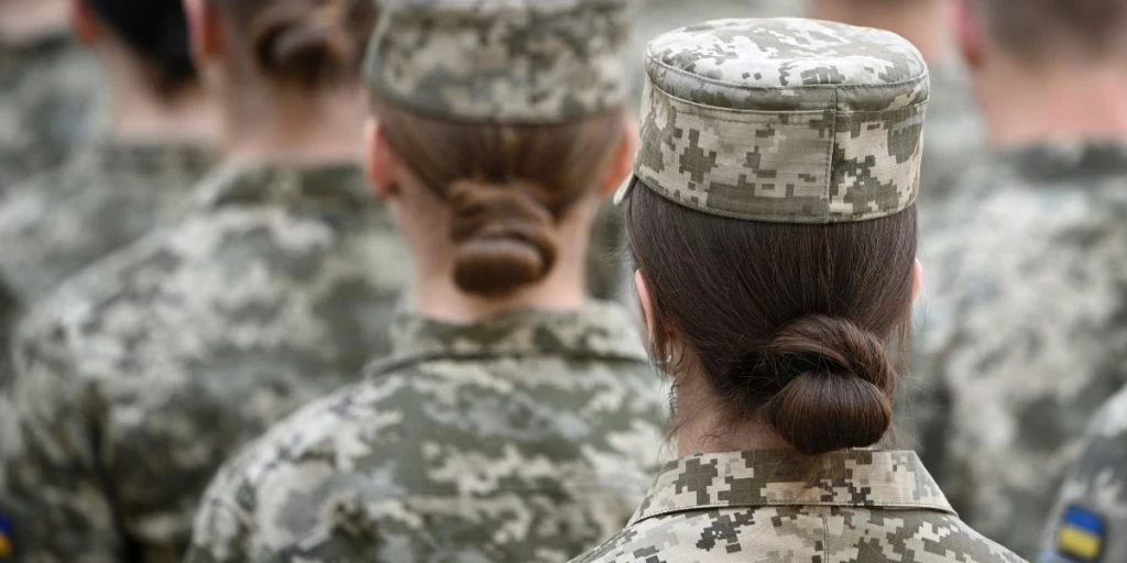 Woman soldier. Woman in army. Ukrainian flag on military uniform. Ukraine troops.
