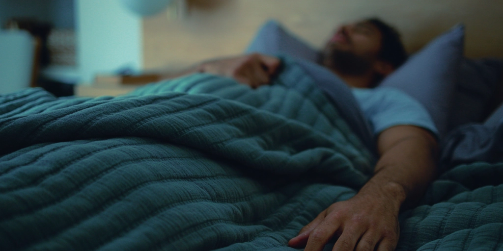 Man sover i sängen