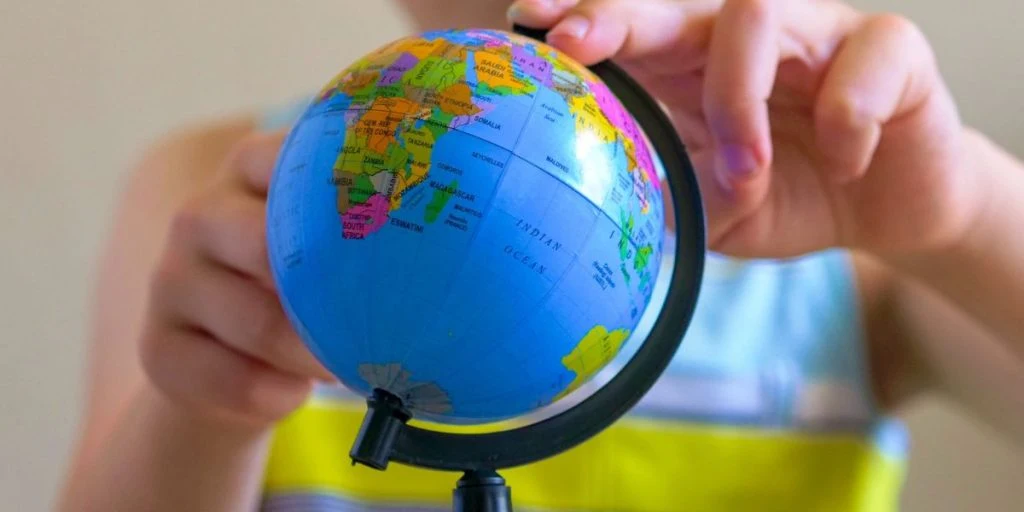 Child spinning a globe