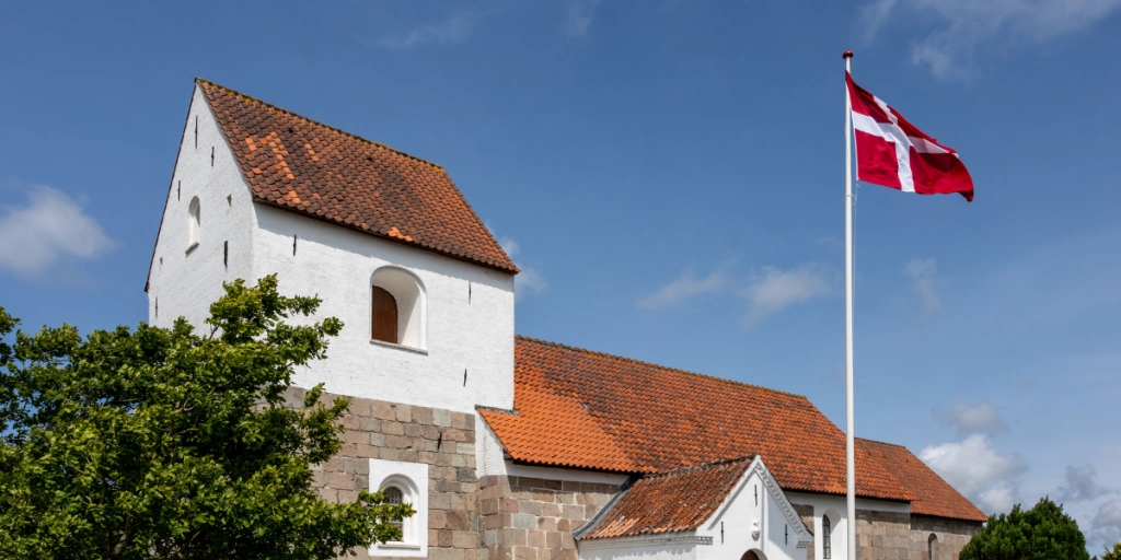 Lerup, Danmark En udsigt over Lerup Kirke på en sommerdag og et dansk flag.