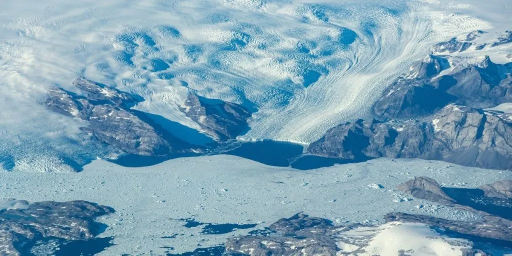 An aerial view of a glacier flowing toward the ocean on Greenland’s east coast. The Greenland ice sheet has recorded 30 consecutive years of net mass loss.