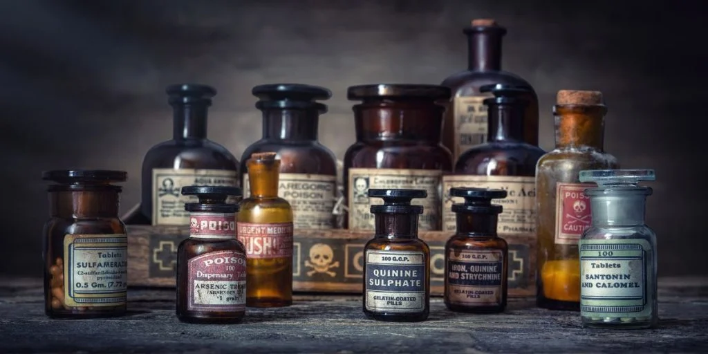 Bottles with drugs from old medical, chemical and pharmaceutical glass. Chemistry and pharmacy history concept background. . Medical substances- sulfamerazin, arsenic trioxid, quinine sulphate etc.
