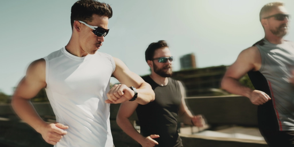 Tre män är ute och joggar och kollar sina pulsmätare