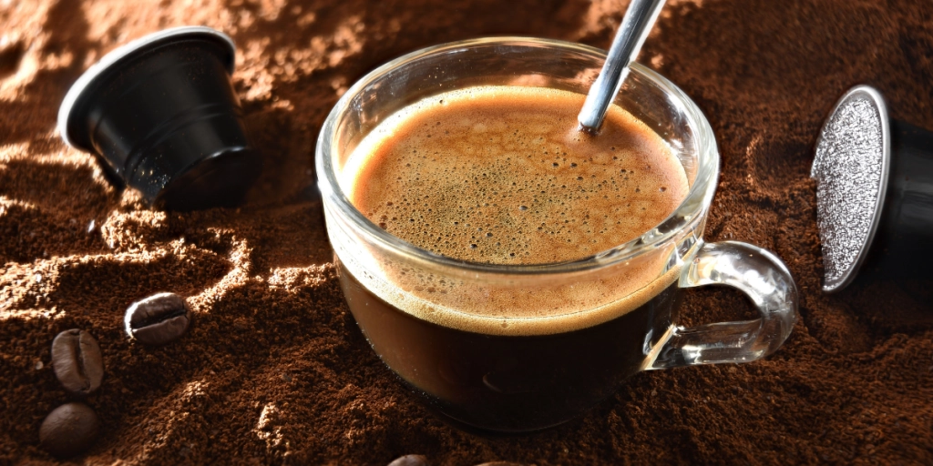 Kapselkaffe och en kopp varm kaffe