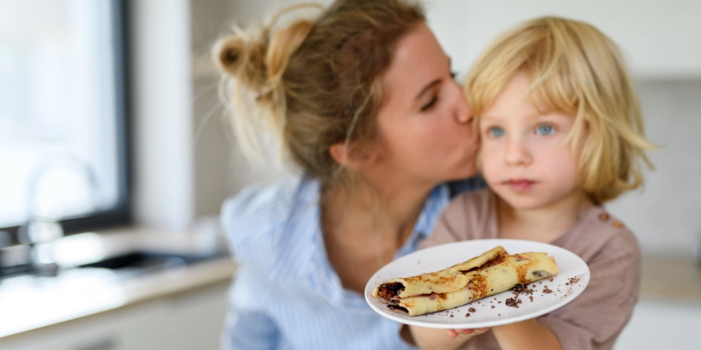 Mamma med dotter äter pannkaka