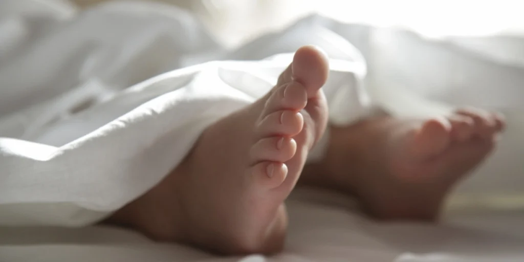 nærbillede af børnefødder under dynen