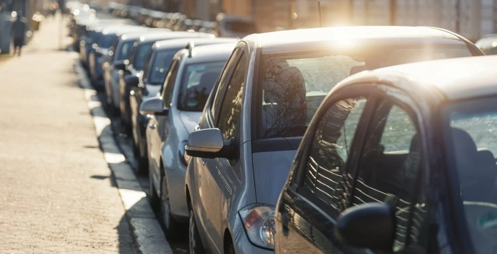 Biler holder parkeret i solen