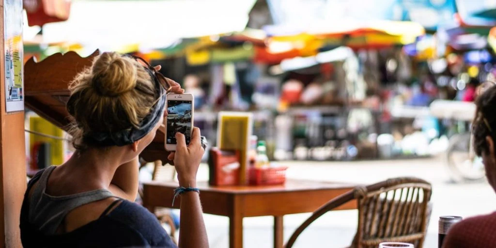 Kvinde tager billede ved cafe i Cambodja