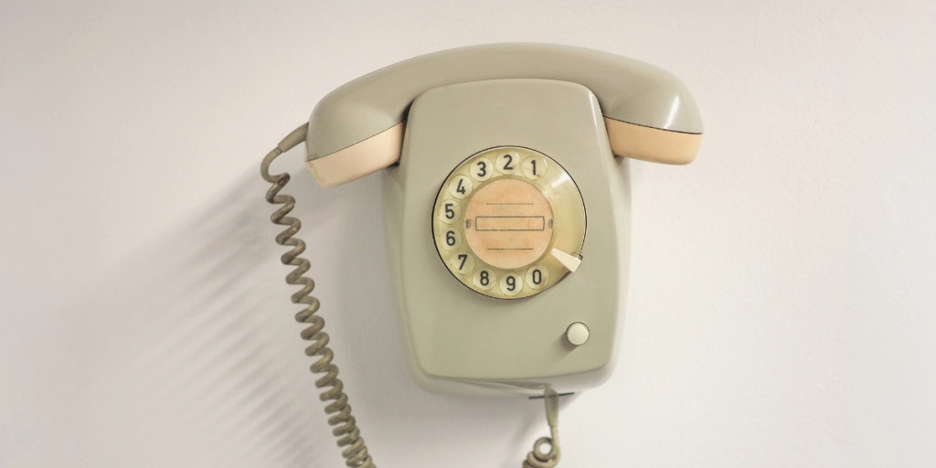 Gammal telefon som hänger på väggen