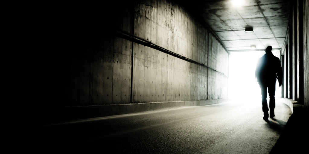 En man går genom en mörk tunnel