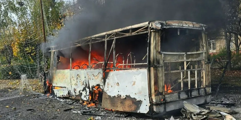 A bus burns after a Russian attack on Kramatorsk in eastern Ukraine. Anti-drone nets are visible behind the vehicle.