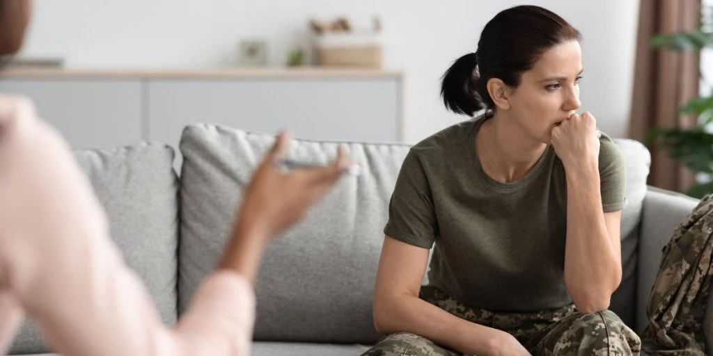 Mental Therapy. Portrait Of Upset Pensive Female Soldier Attending Meeting With Psychologist, Thoughtful Woman In Military Uniform Sitting On Couch And Looking Away, Suffering Depression Or PTSD
