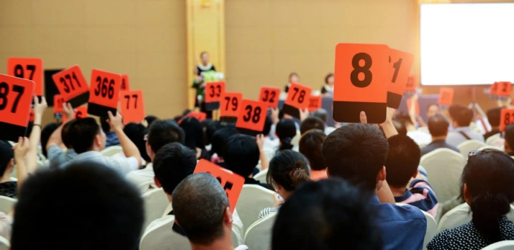 Crowd,Of,Bidders,Holding,Their,Numbered,Bidding,Paddles,At,An, Auction, akusjon