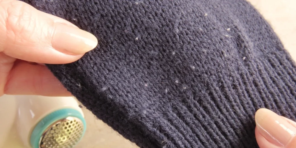Hands,Holding,Dark,Blue,Sweater,With,Pills., pilling, nupper, uldtrøje, ullgenser